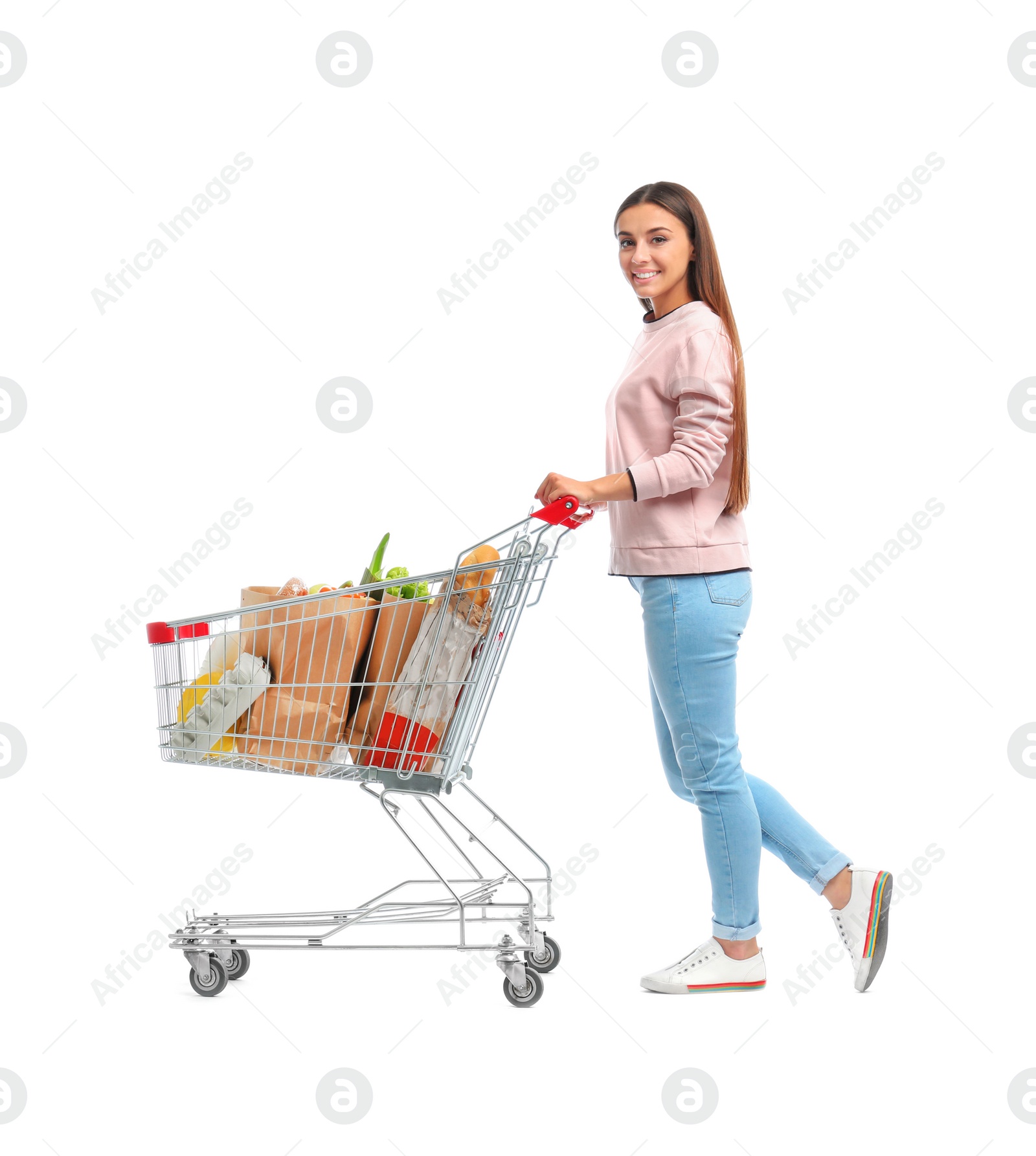 Photo of Young woman with full shopping cart on white background
