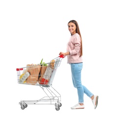 Young woman with full shopping cart on white background