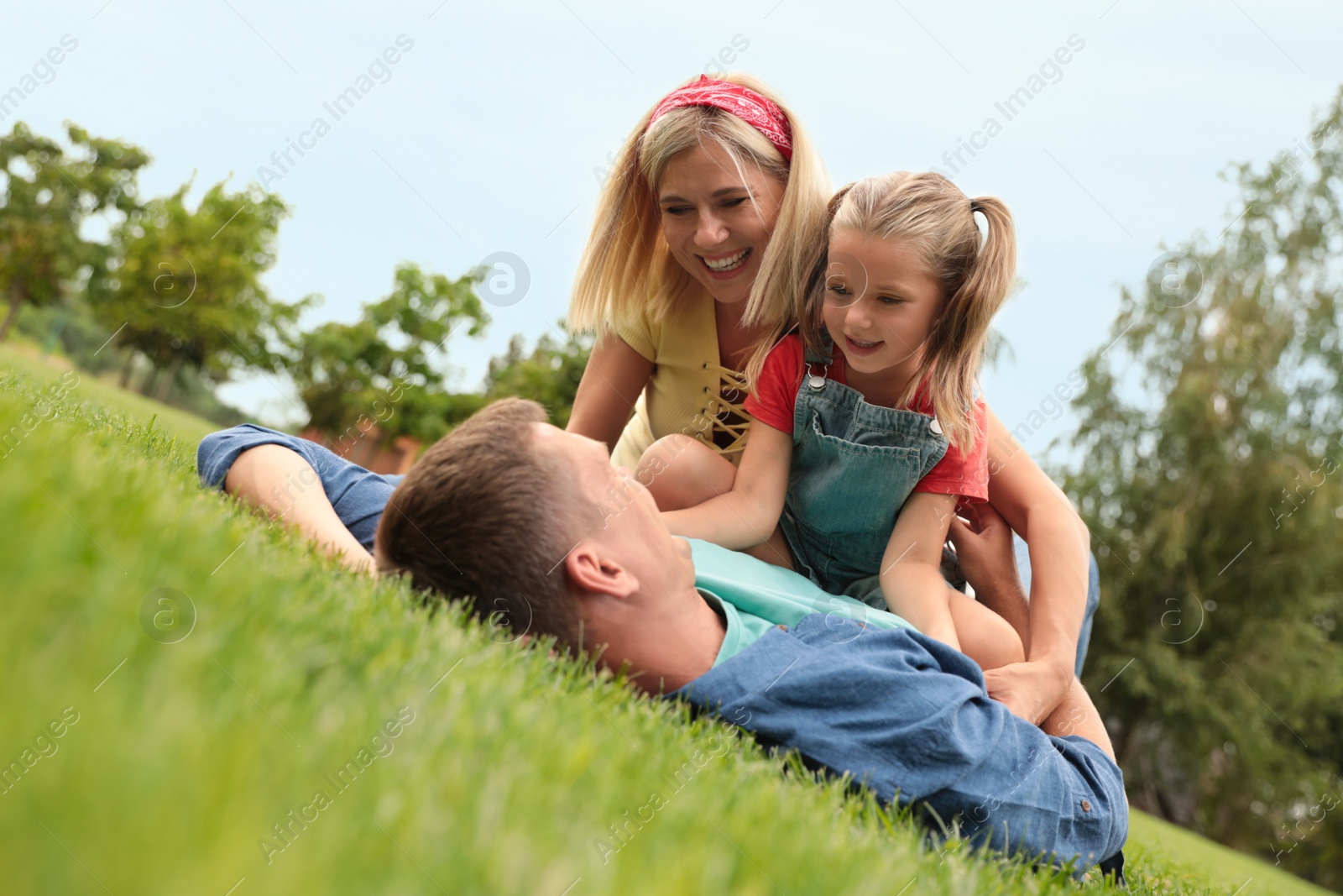 Photo of Happy family spending time together in park on green grass