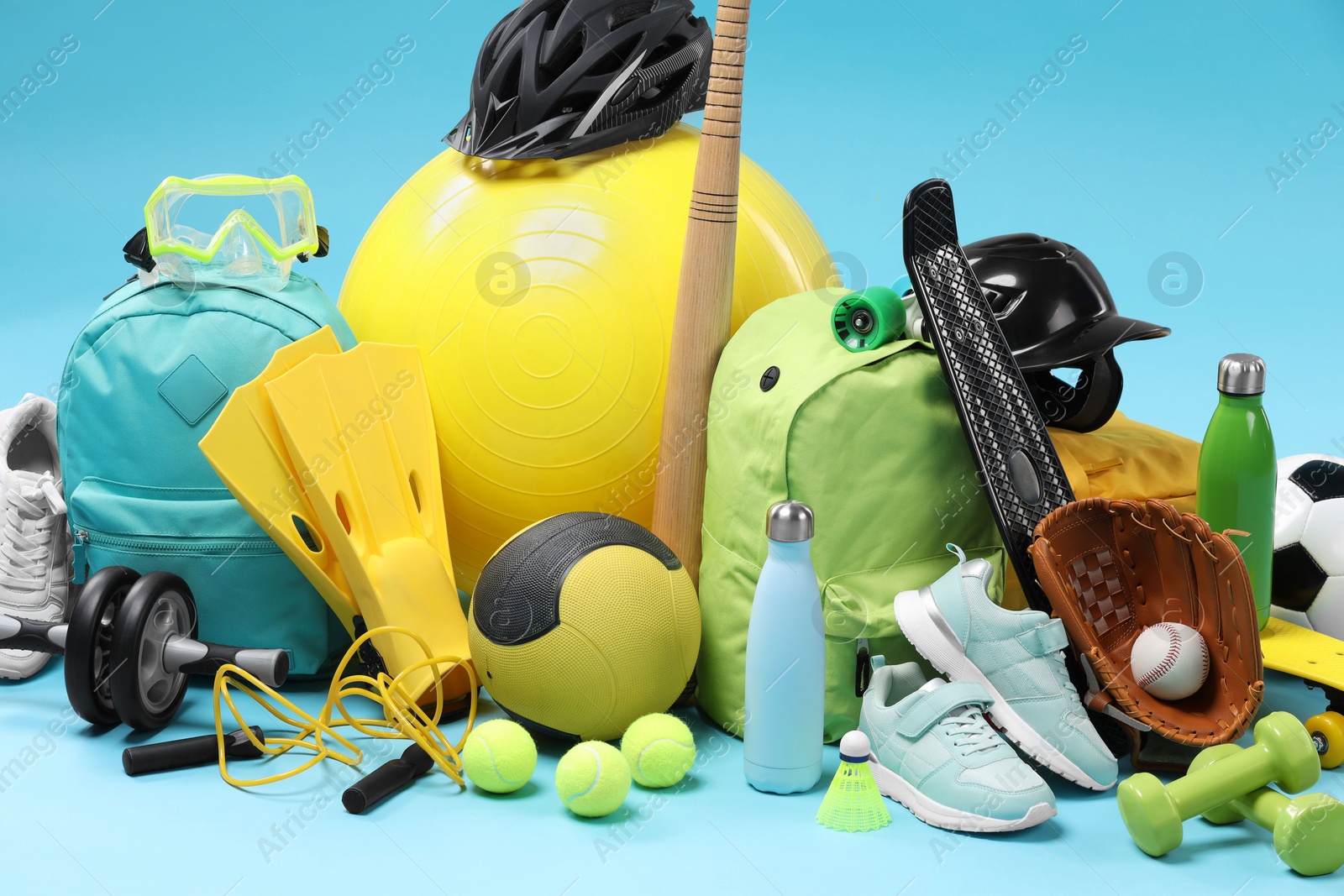 Photo of Many different sports equipment on light blue background