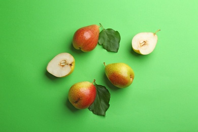 Ripe juicy pears on green background, flat lay