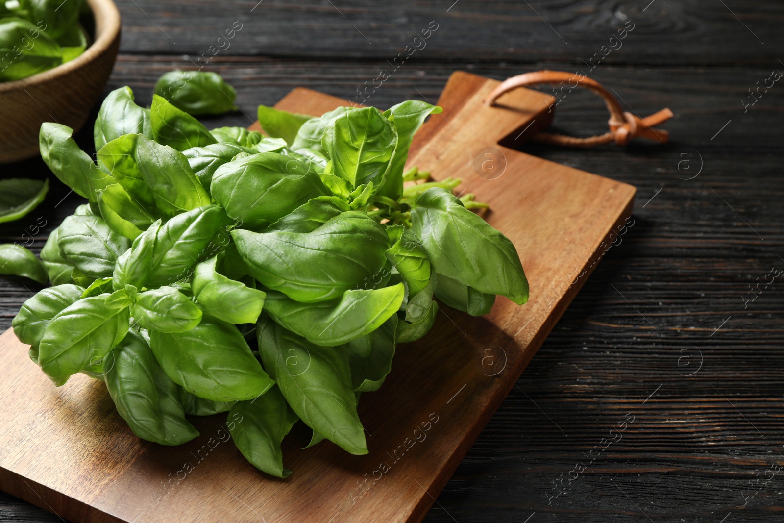 Photo of Fresh green basil on black wooden table