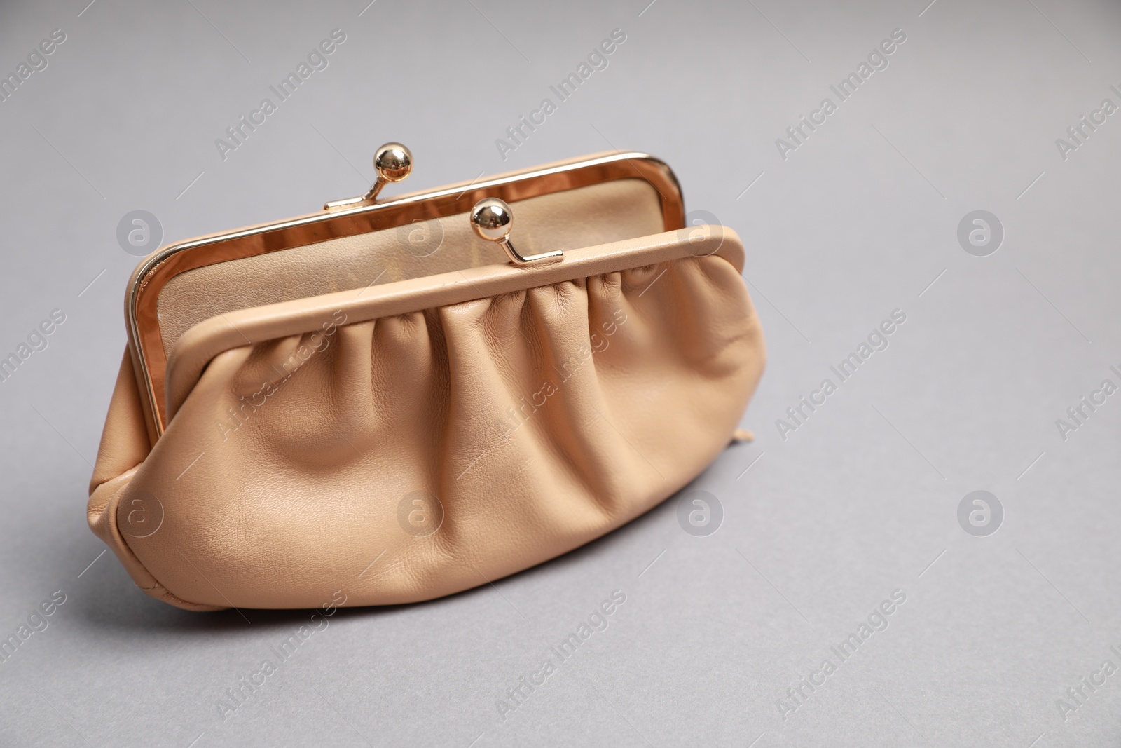 Photo of Stylish beige leather purse on light grey background. Space for text