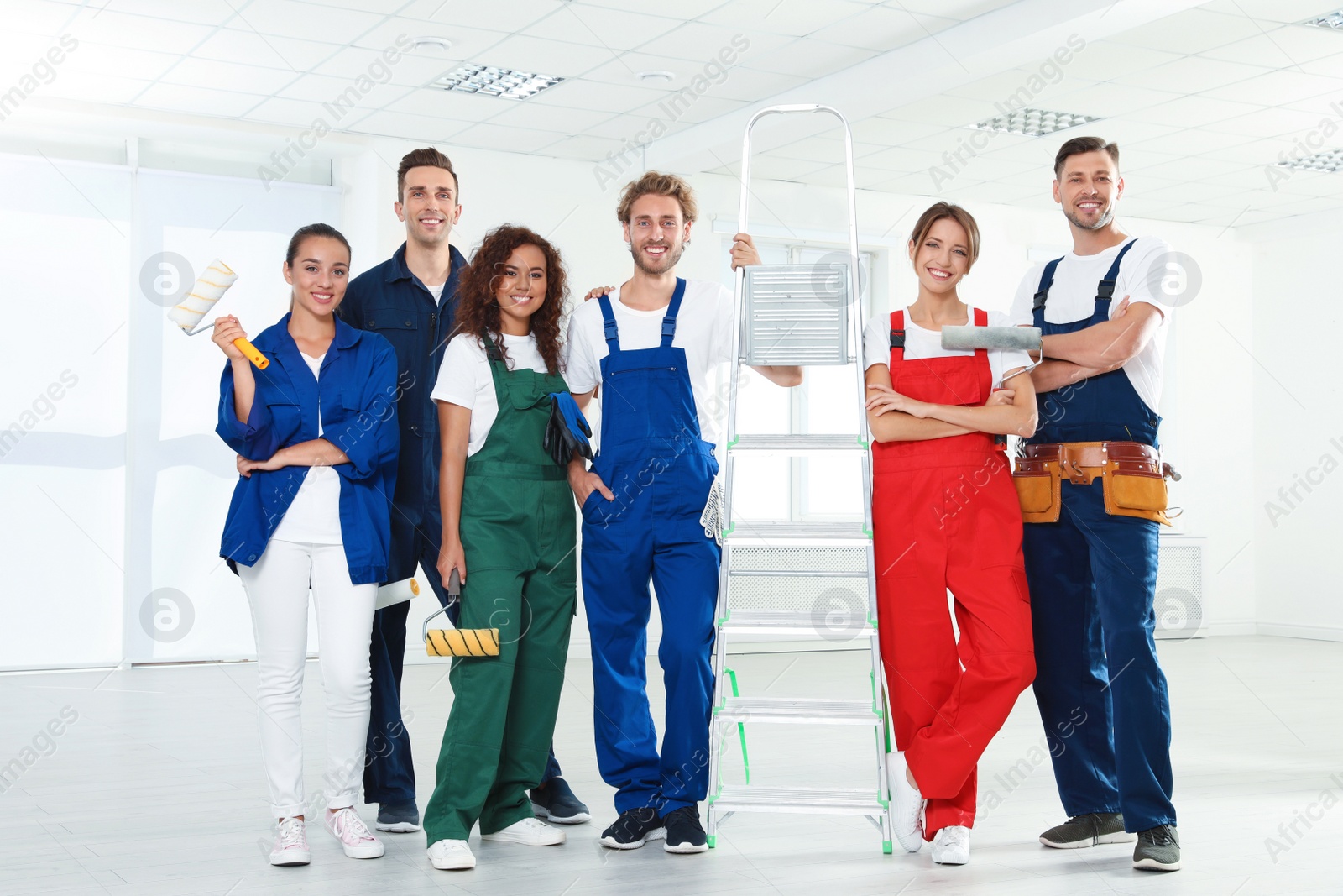 Photo of Team of professional painters with tools indoors