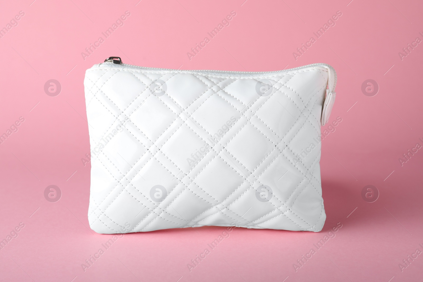 Photo of White leather cosmetic bag on pink background