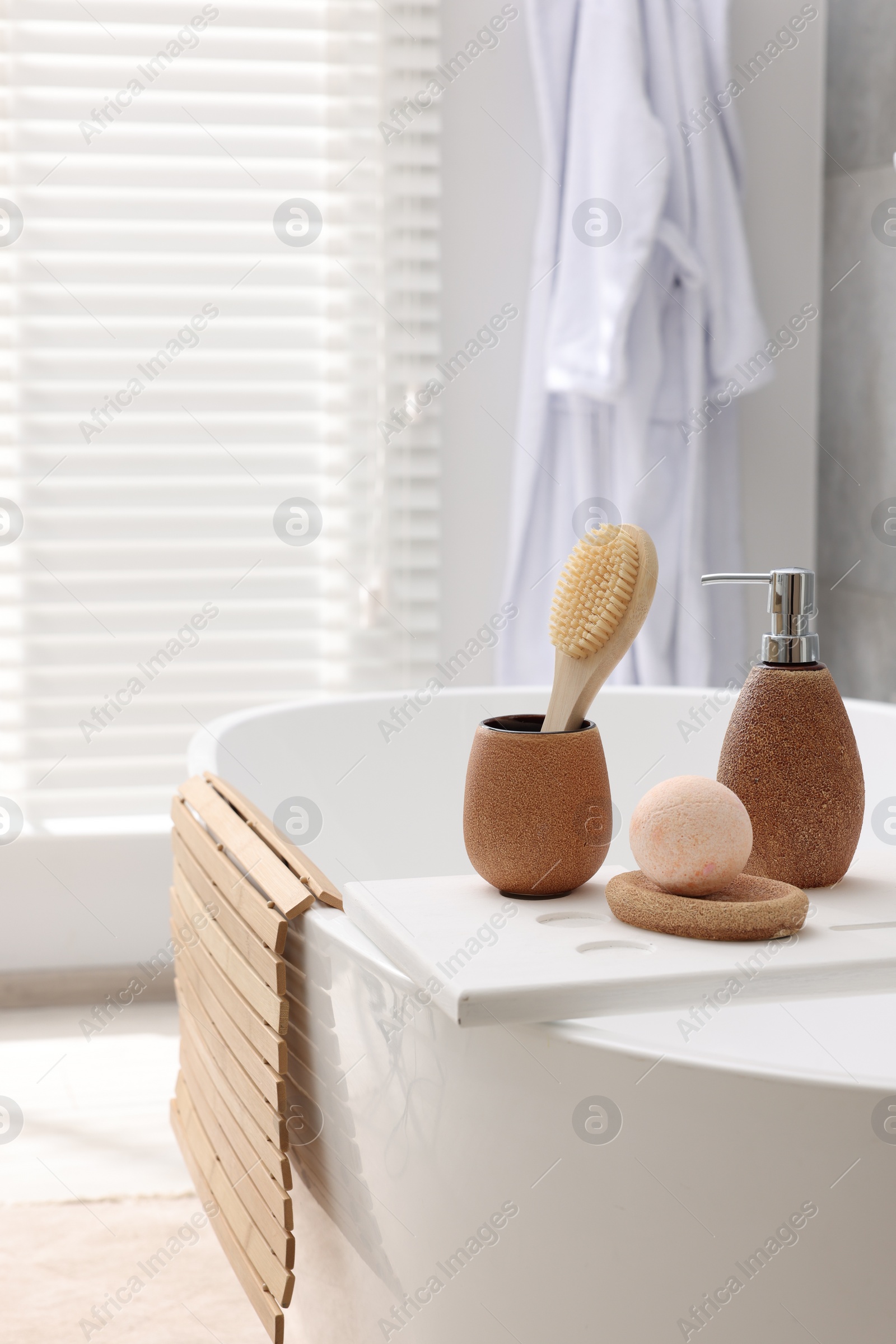 Photo of Different personal care products and accessories on bath tub in bathroom