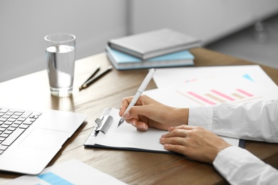 Business trainer working at table in office, closeup