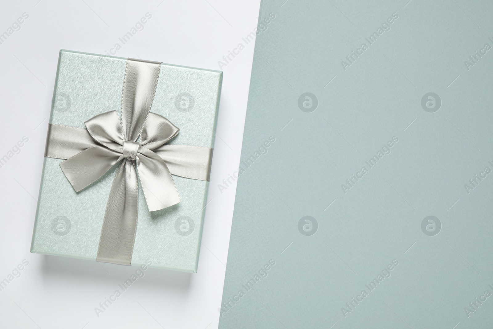 Photo of Beautiful gift box on color background, top view. Space for text