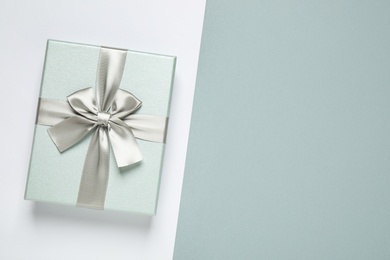 Photo of Beautiful gift box on color background, top view. Space for text