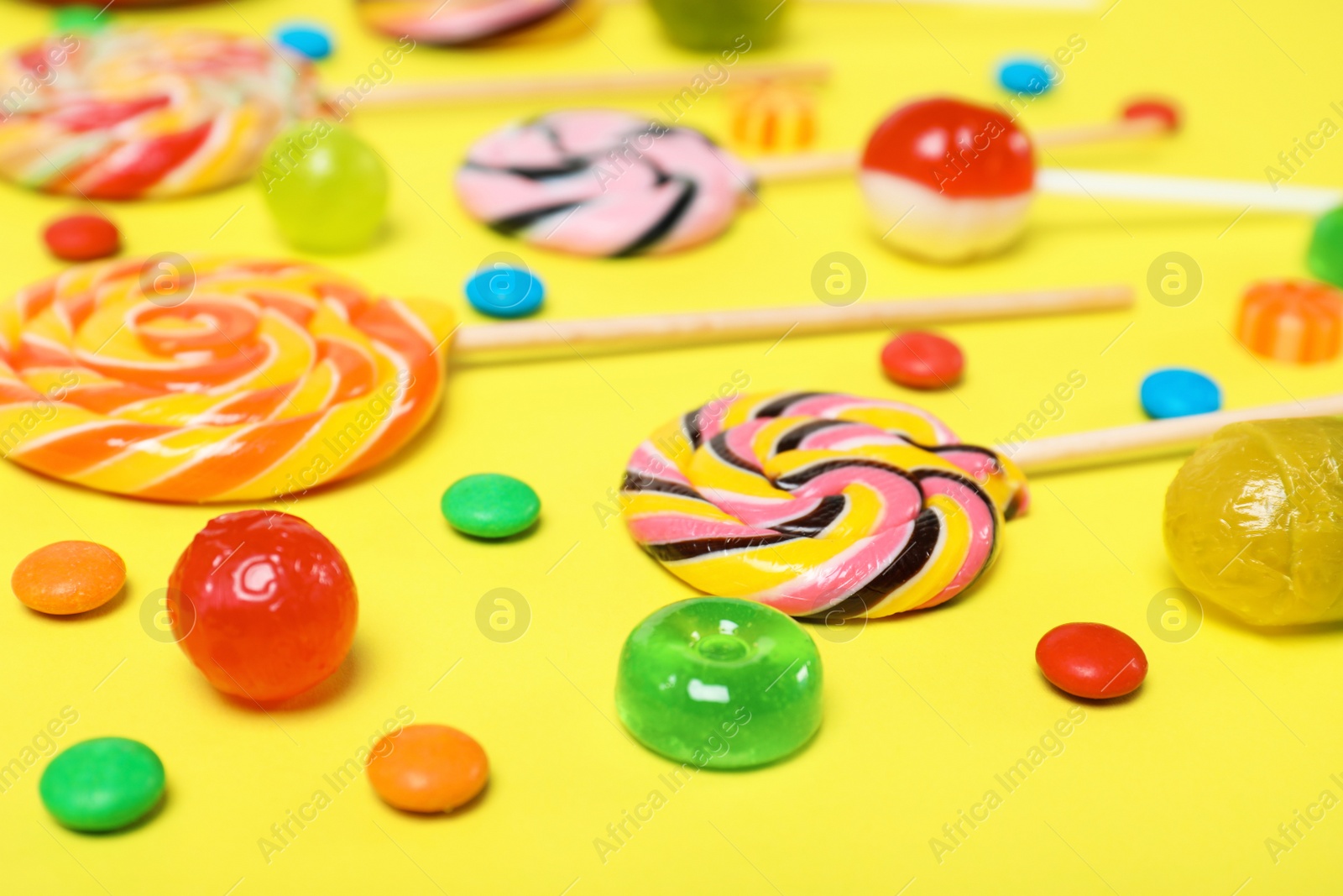 Photo of Many different tasty candies on color background, closeup