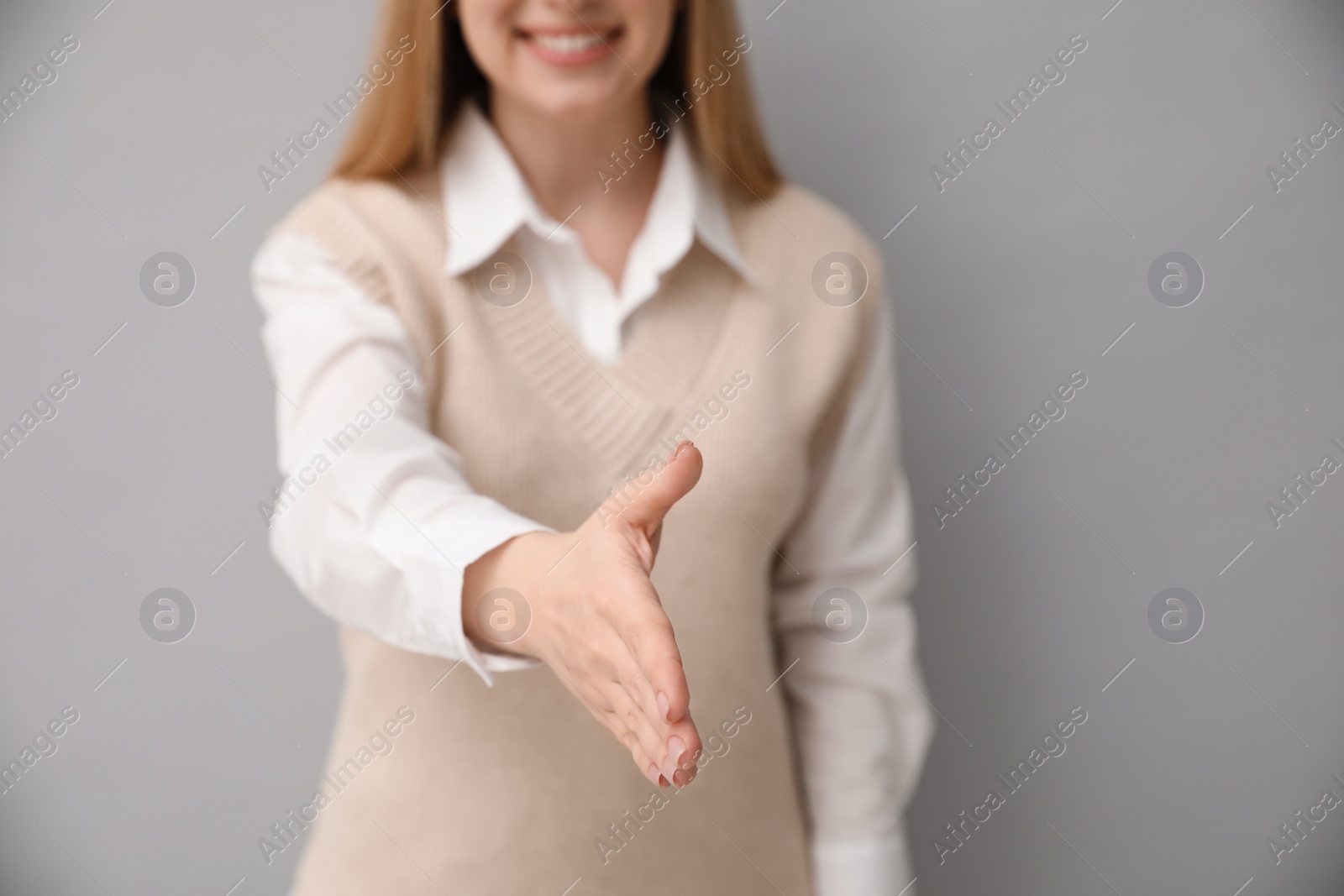 Photo of Woman offering handshake on light grey background, closeup