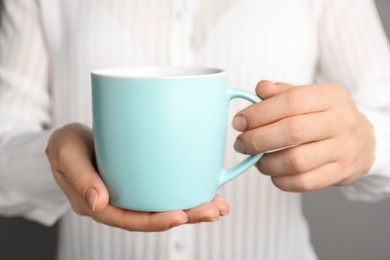 Woman holding mug of hot drink, closeup. Coffee Break