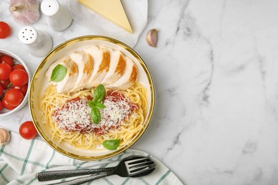 Delicious pasta with tomato sauce, chicken and parmesan cheese on white marble table, flat lay. Space for text
