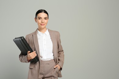 Photo of Beautiful real estate agent with documents on grey background. Space for text