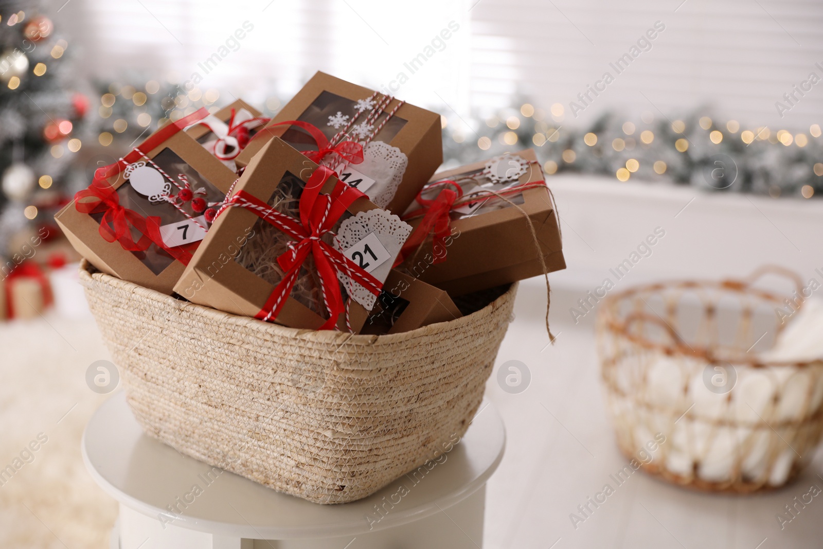 Photo of Basket full of gift boxes for Christmas advent calendar in room