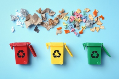 Trash bins and different garbage on color background, top view. Waste recycling concept