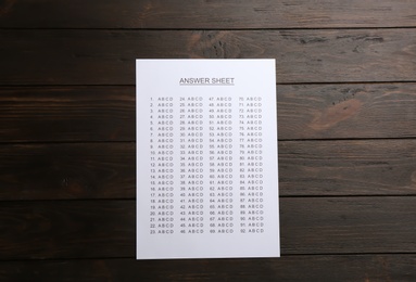 Photo of Answer sheet on wooden background, top view