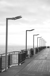 Beautiful view of pier near sea outdoors, toned in black and white