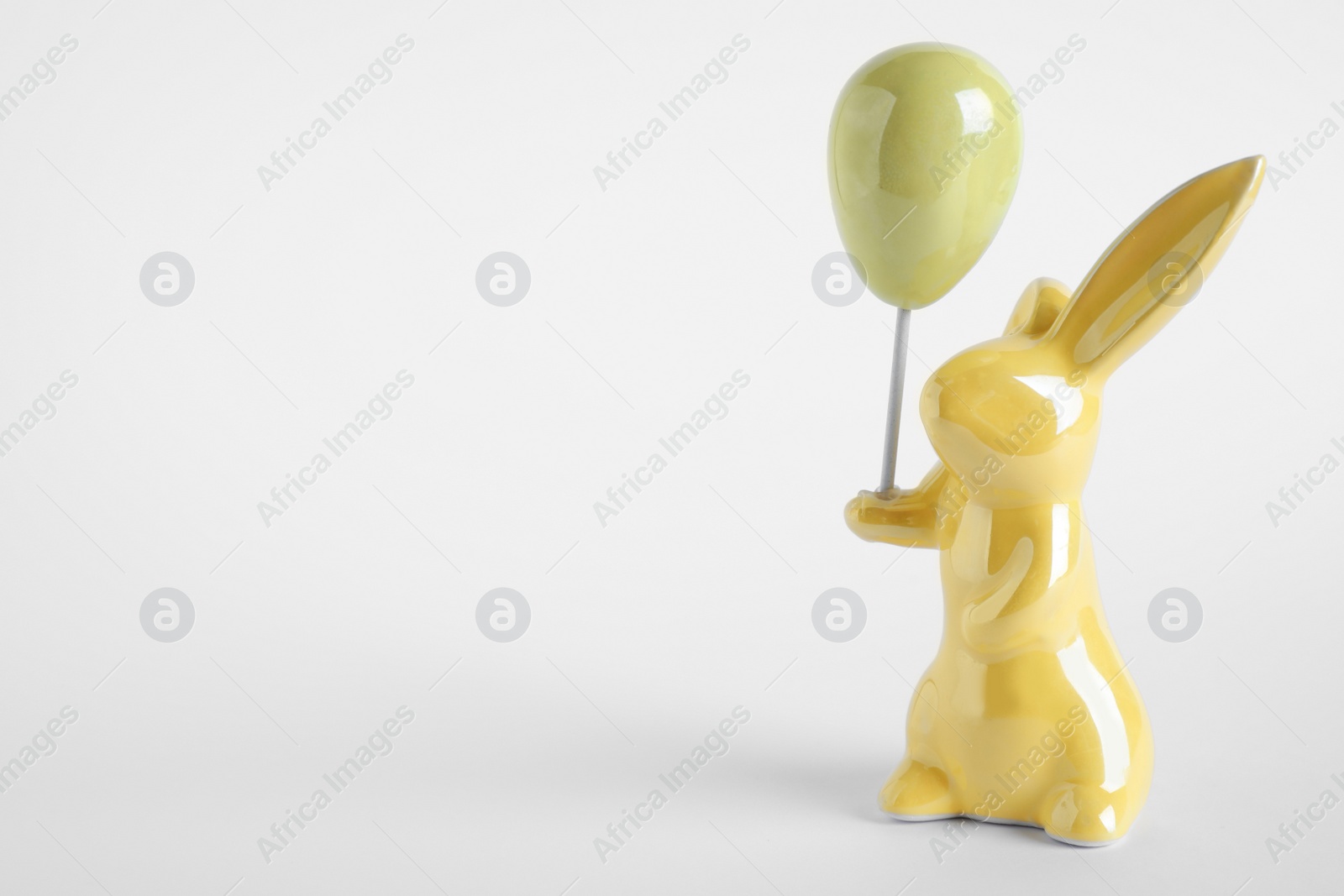 Photo of Easter bunny figure on white background. Space for text