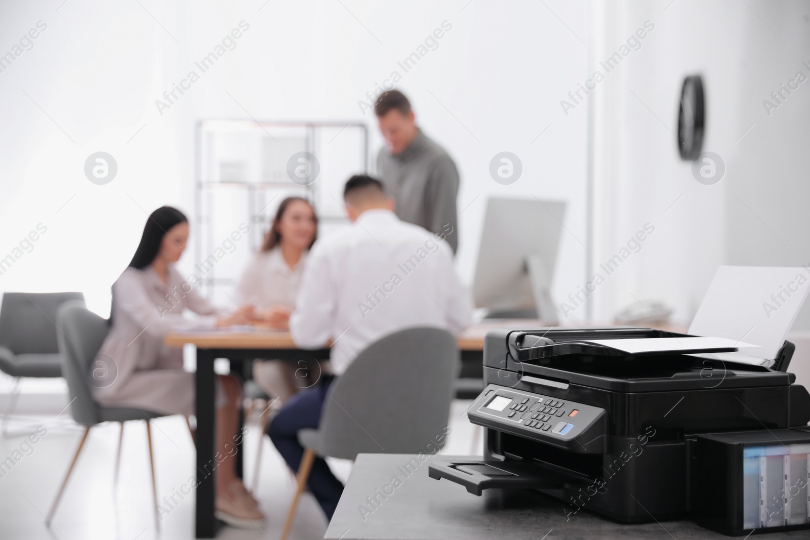 Photo of New modern printer on table in office. Space for text