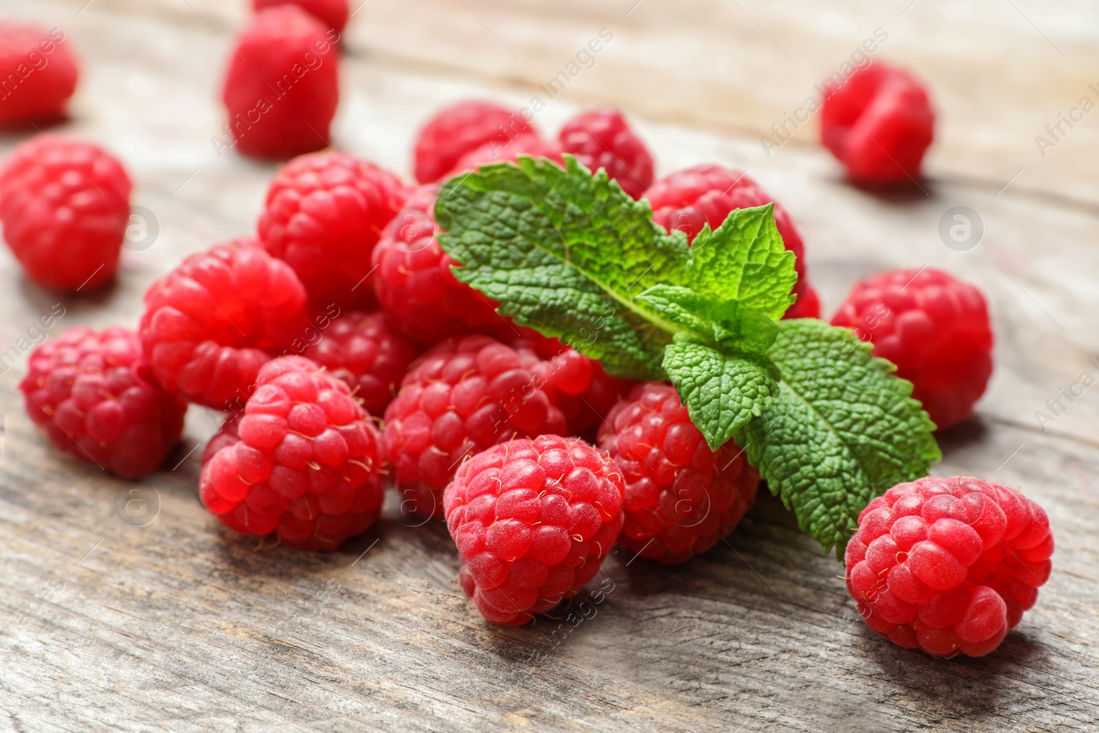 Photo of Ripe aromatic raspberries on wooden table