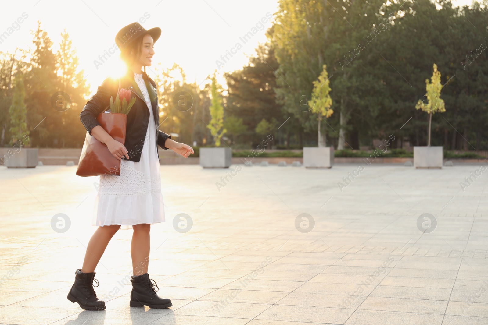 Photo of Young woman with leather shopper bag on city street