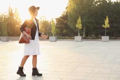 Photo of Young woman with leather shopper bag on city street