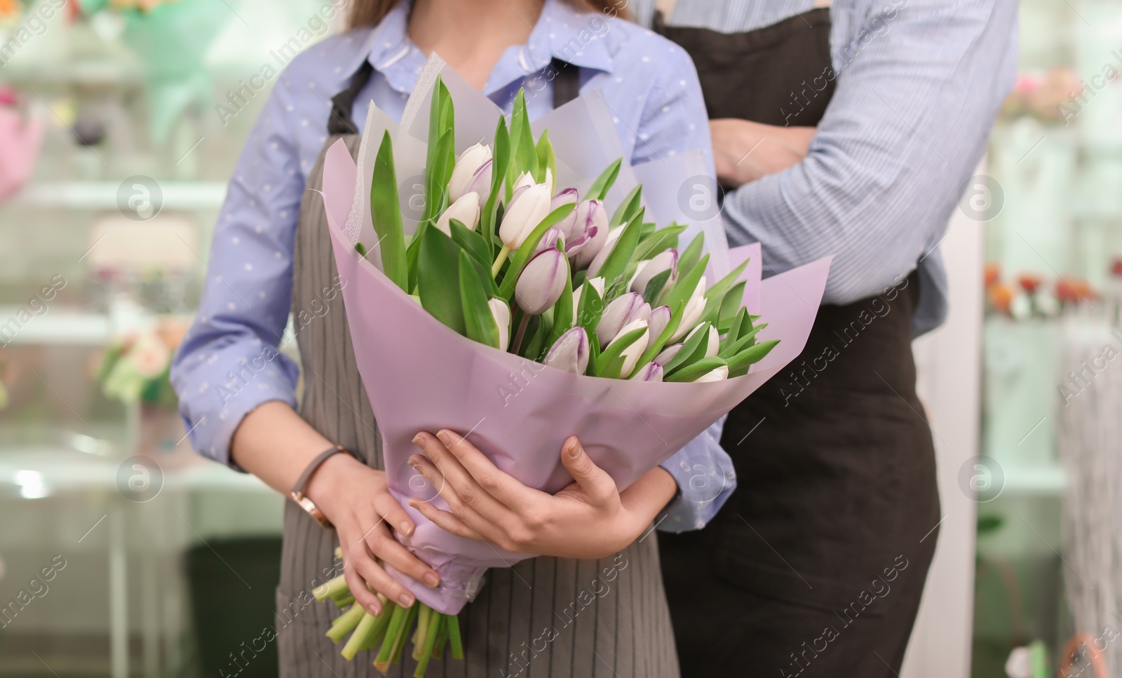 Photo of Male and female florists with bouquet flowers at workplace