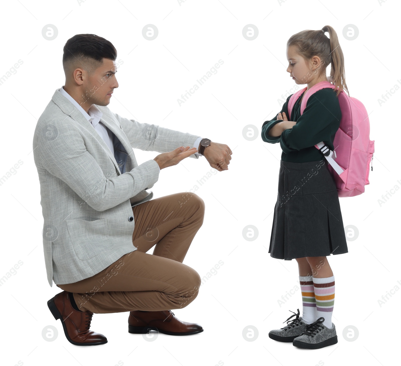 Photo of Teacher pointing on wrist watch while scolding pupil for being late against white background