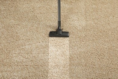 Hoovering carpet with vacuum cleaner, above view and space for text. Clean trace on dirty surface