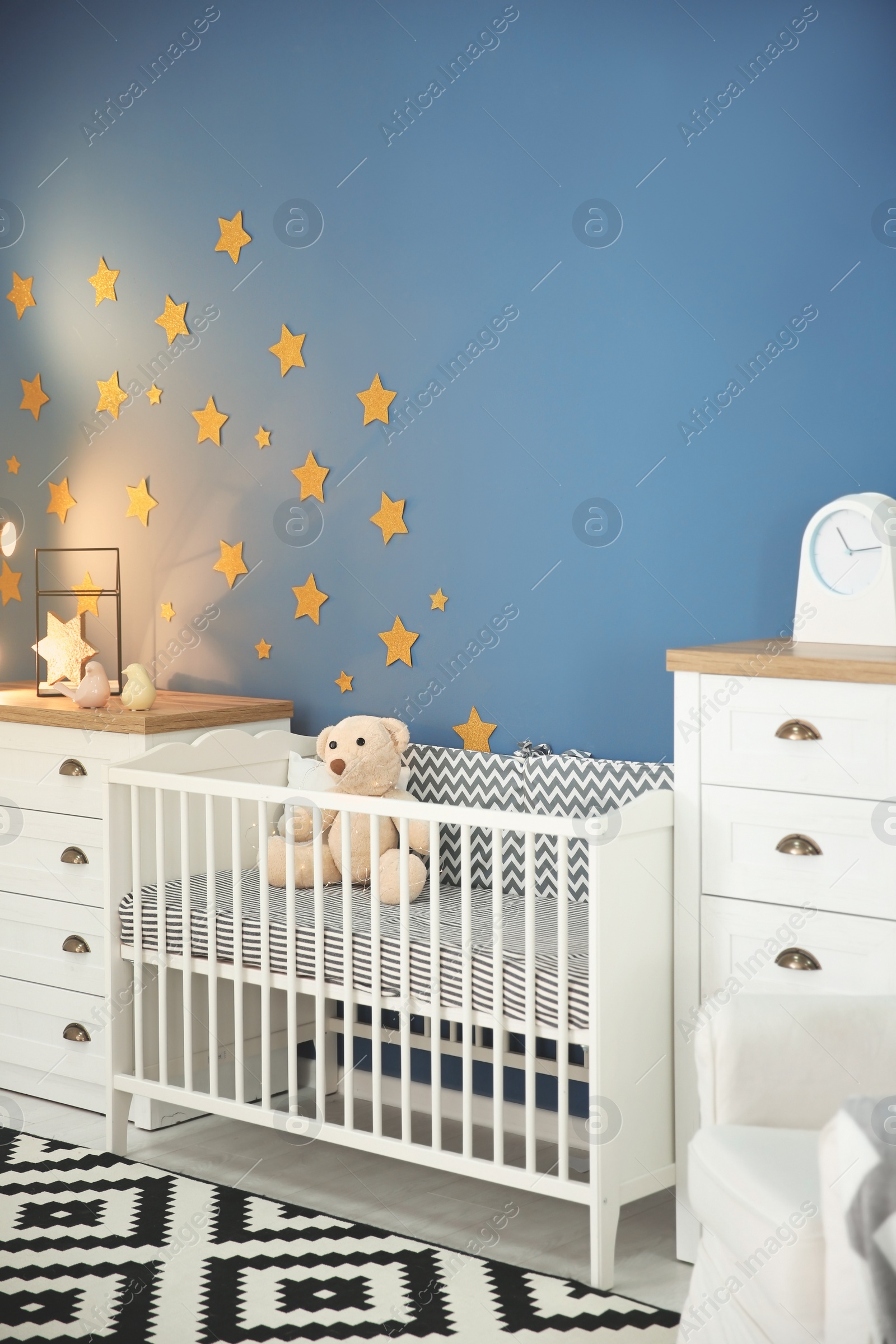 Photo of Stylish baby room interior with comfortable crib