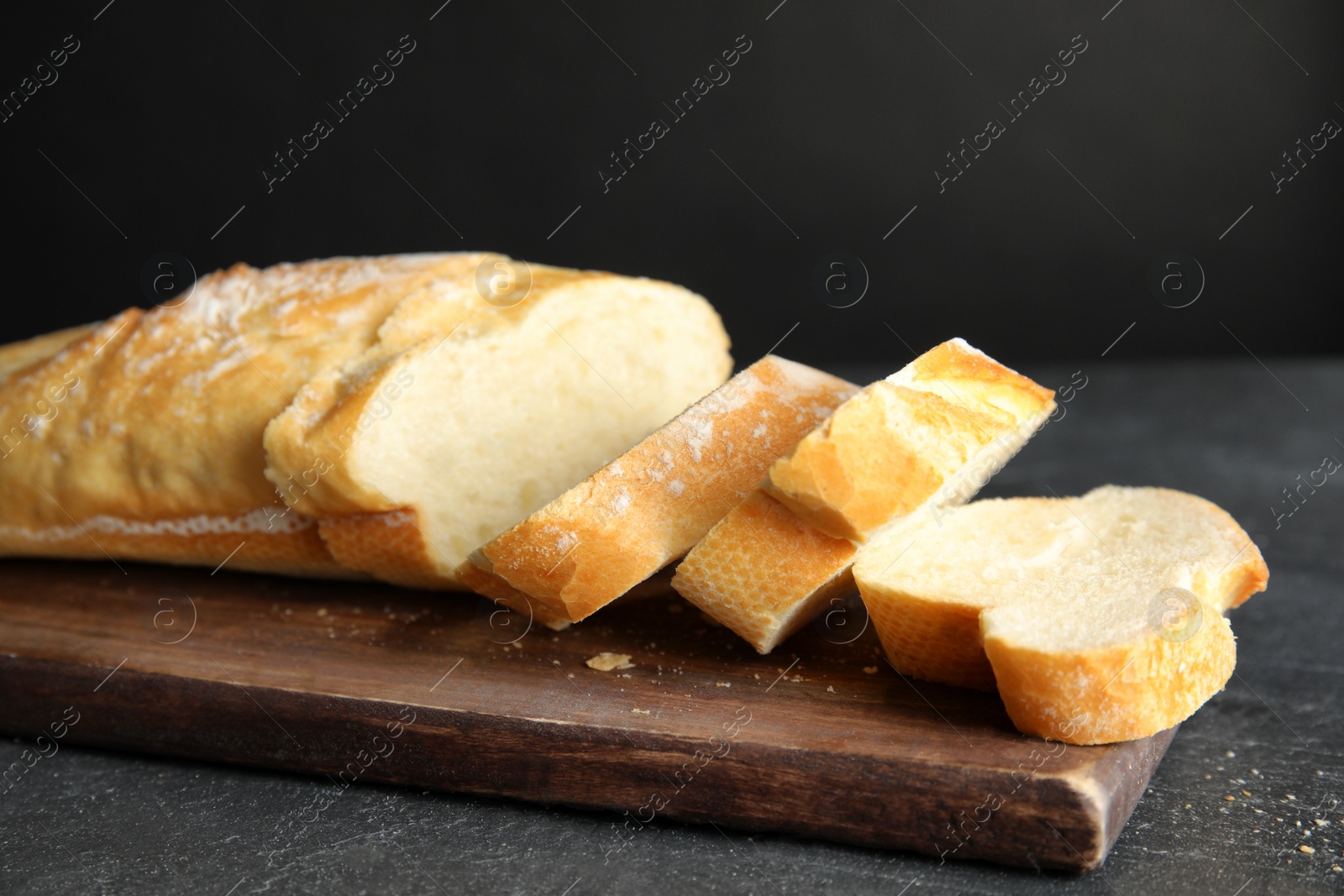 Photo of Board with tasty wheat bread on table