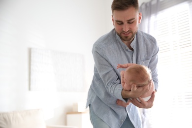 Photo of Father with his newborn son at home. Space for text