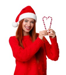 Young woman in red sweater and Santa hat with candy canes on white background. Christmas celebration