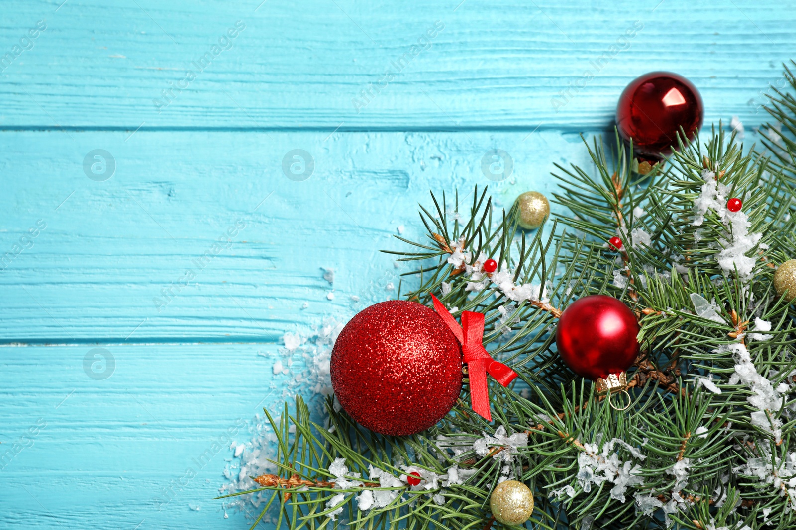 Photo of Fir tree branches with Christmas decoration on light blue wooden background, flat lay. Space for text