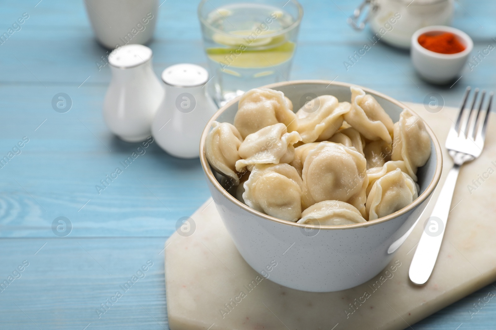 Photo of Delicious dumplings on turquoise wooden table, space for text