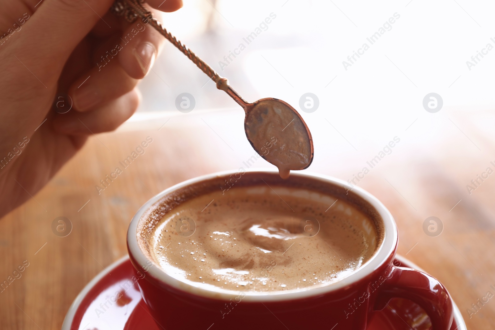 Photo of Woman with cup of fresh aromatic coffee at table, closeup