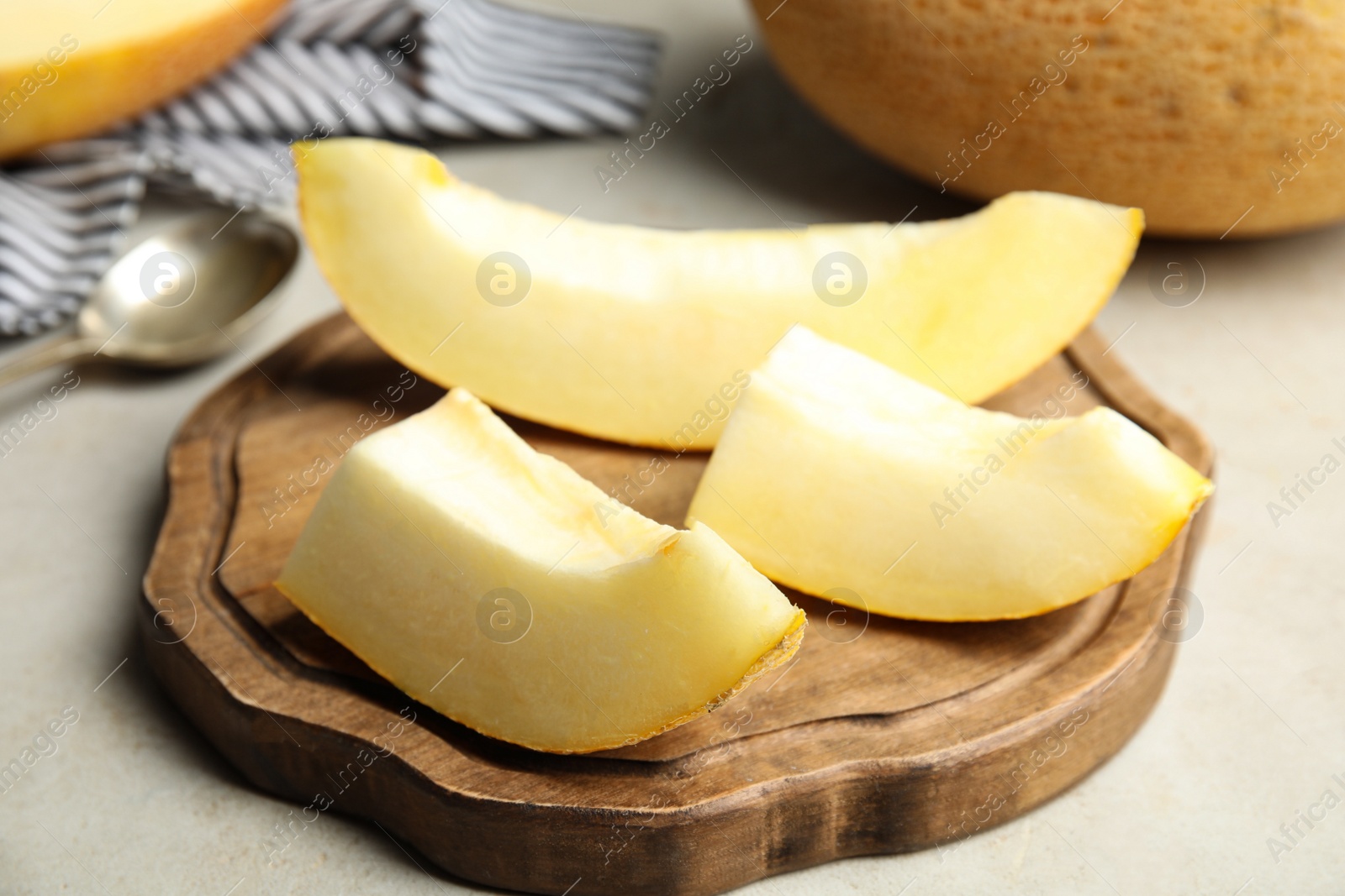Photo of Wooden board with slices of ripe melon on table, closeup