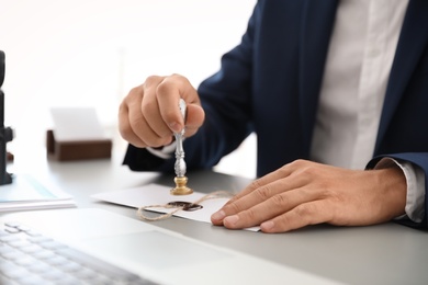 Photo of Notary stamping document at desk in office, closeup