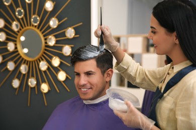 Photo of Professional hairdresser dying hair in beauty salon