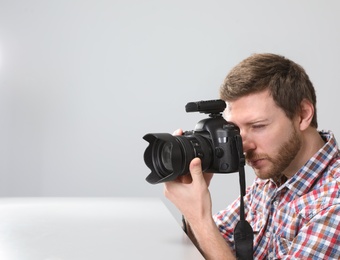 Photo of Man with professional camera in photo studio. Space for text