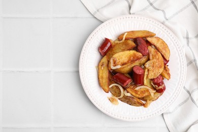 Photo of Delicious baked potato with thin dry smoked sausages and onion on white tiled table, top view. Space for text