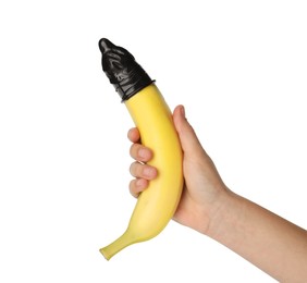 Photo of Woman holding banana in condom on white background, closeup. Safe sex concept