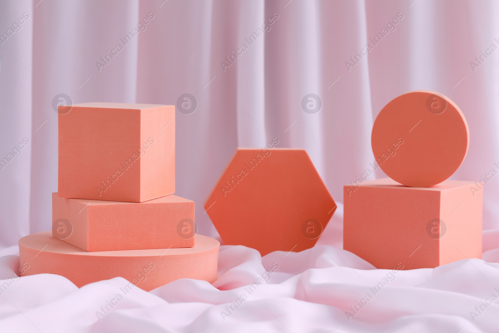 Photo of Geometric figures on pink fabric. Stylish presentation for product