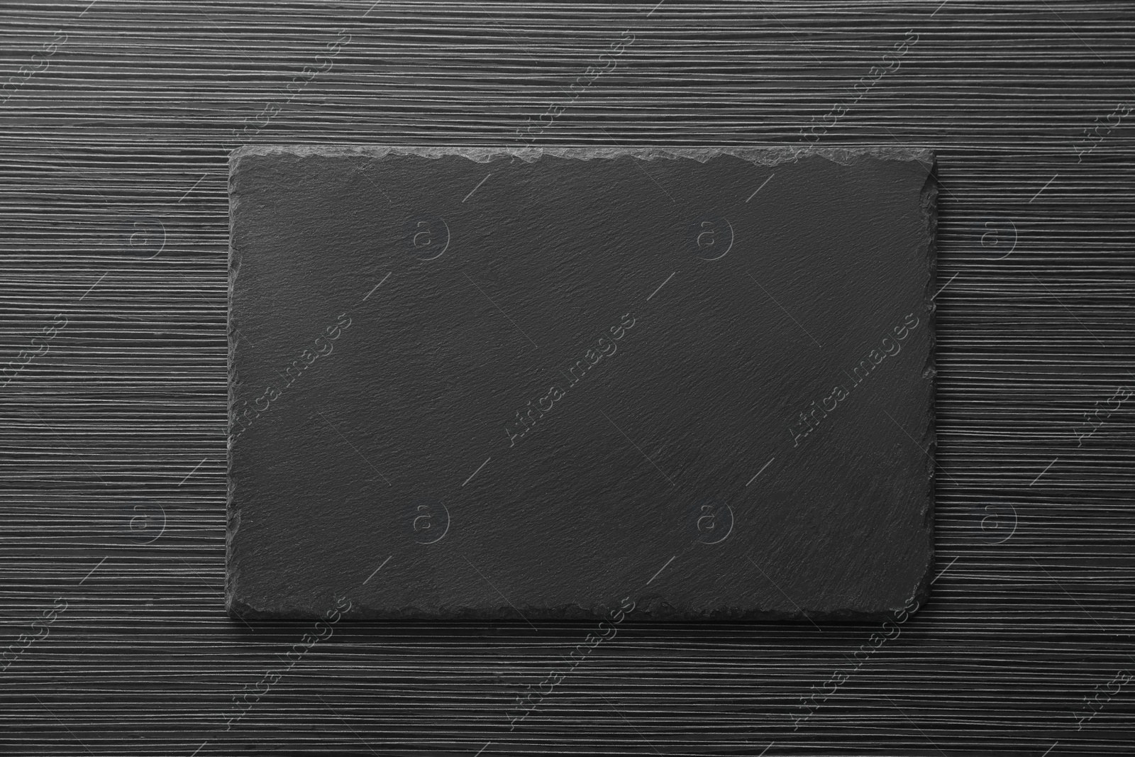 Photo of Slate board on black wooden table, top view