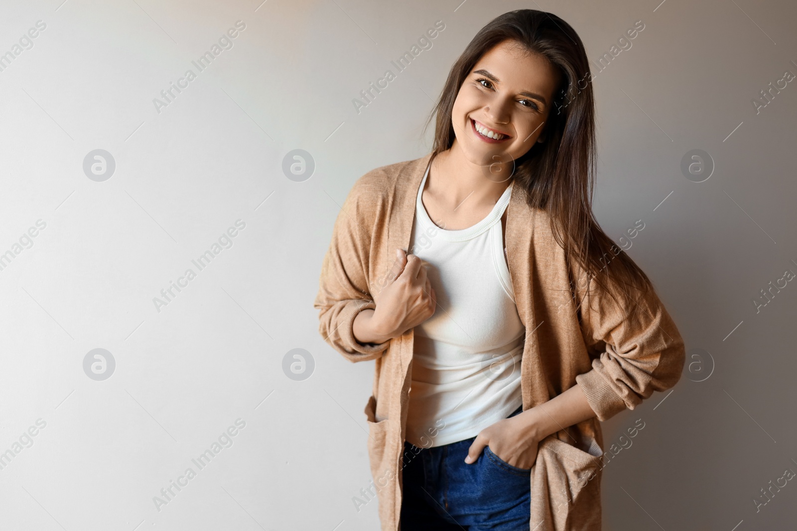 Photo of Portrait of beautiful young woman on beige background, space for text