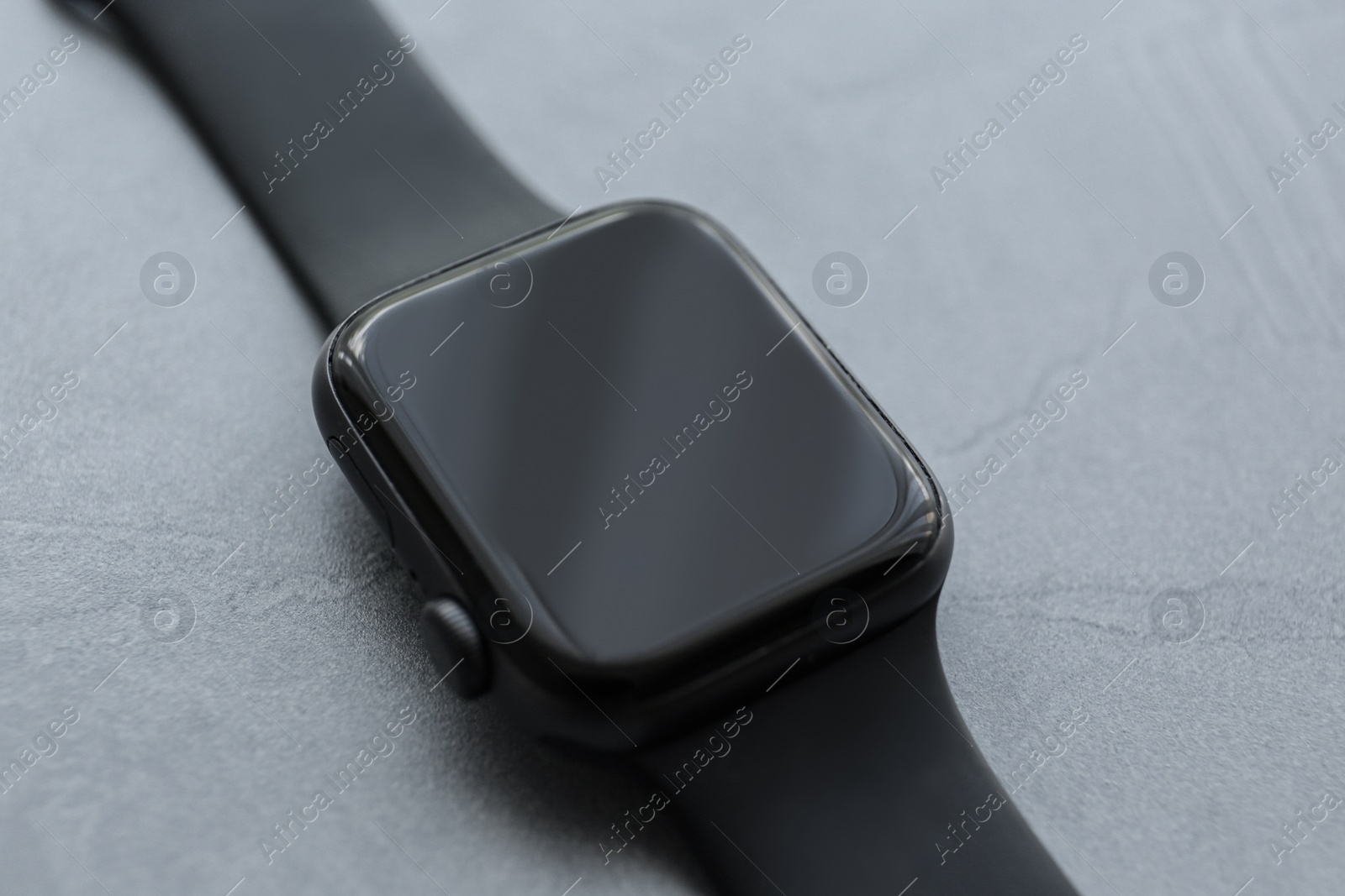 Stylish smart watch on grey stone table, closeup Photo of Stylish smart watch on grey stone table, closeup