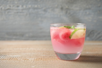 Photo of Tasty refreshing watermelon drink on wooden table. Space for text