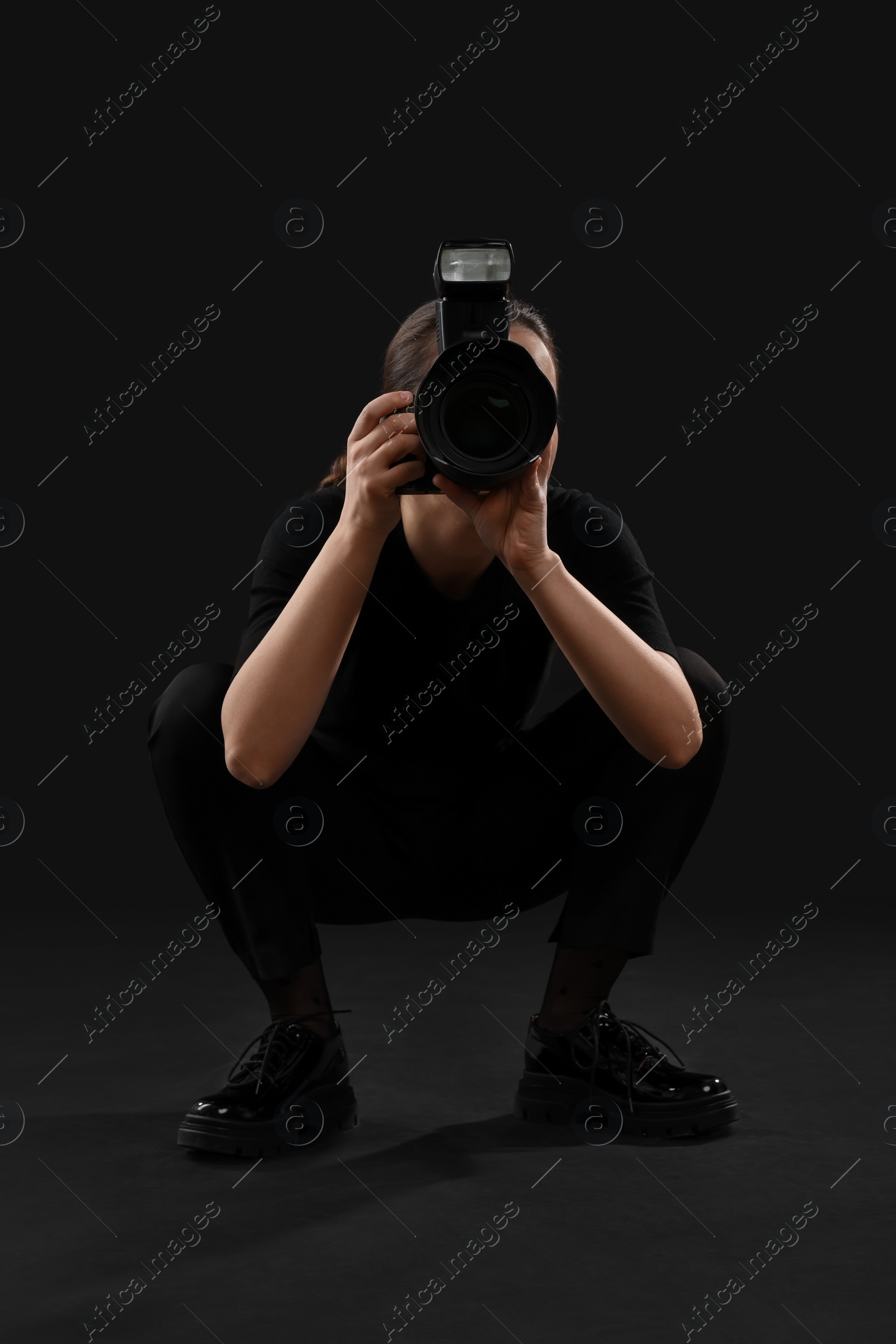 Photo of Professional photographer taking picture on black background