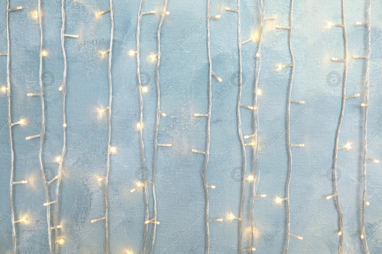 Photo of Glowing Christmas garland on light background